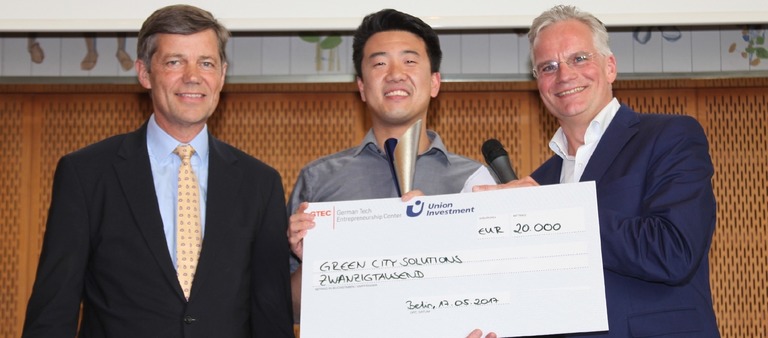Liang Wu (Mitte), CIO von Green City Solutions, empfängt den PropTech Innovation Award 2017. Links im Bild: Dr. Reinhard Kutscher von Sponsor Union Investment. Rechts zu sehen: Wolfgang Schäfers aus der Award-Jury.  