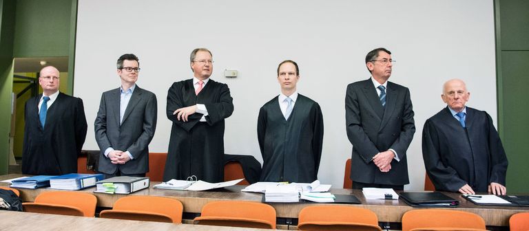Die Angeklagten Markus Fell (Zweiter von links) und Georg Funke (Zweiter von rechts) umringt von ihren Anwälten. 